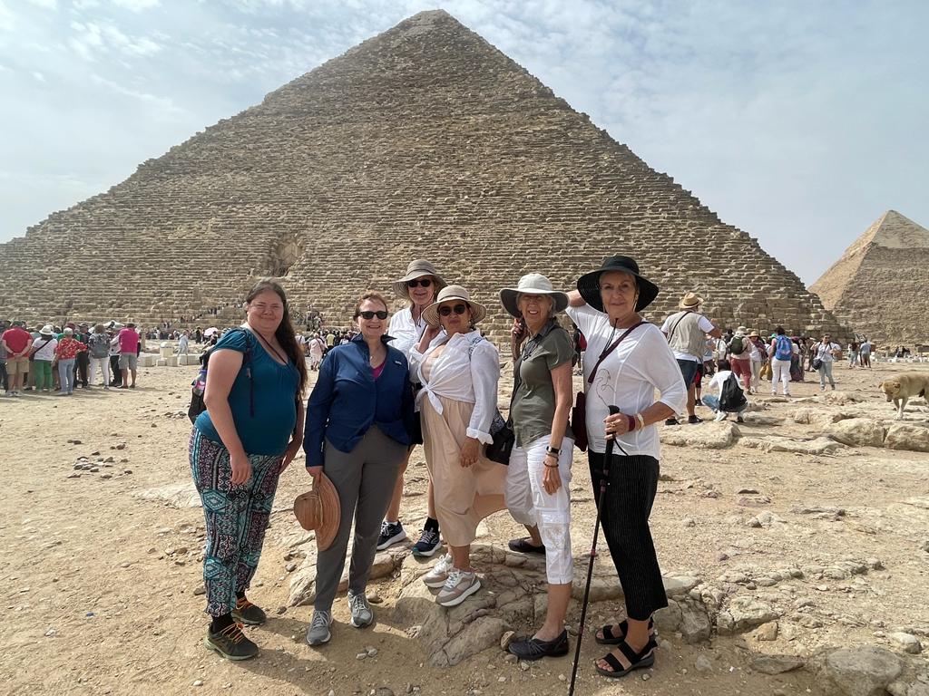 WTA traveler exploring the scenic views of Egypt with the pyramids in the background WTA traveler exploring the scenic views of Egypt with the pyramids in the background