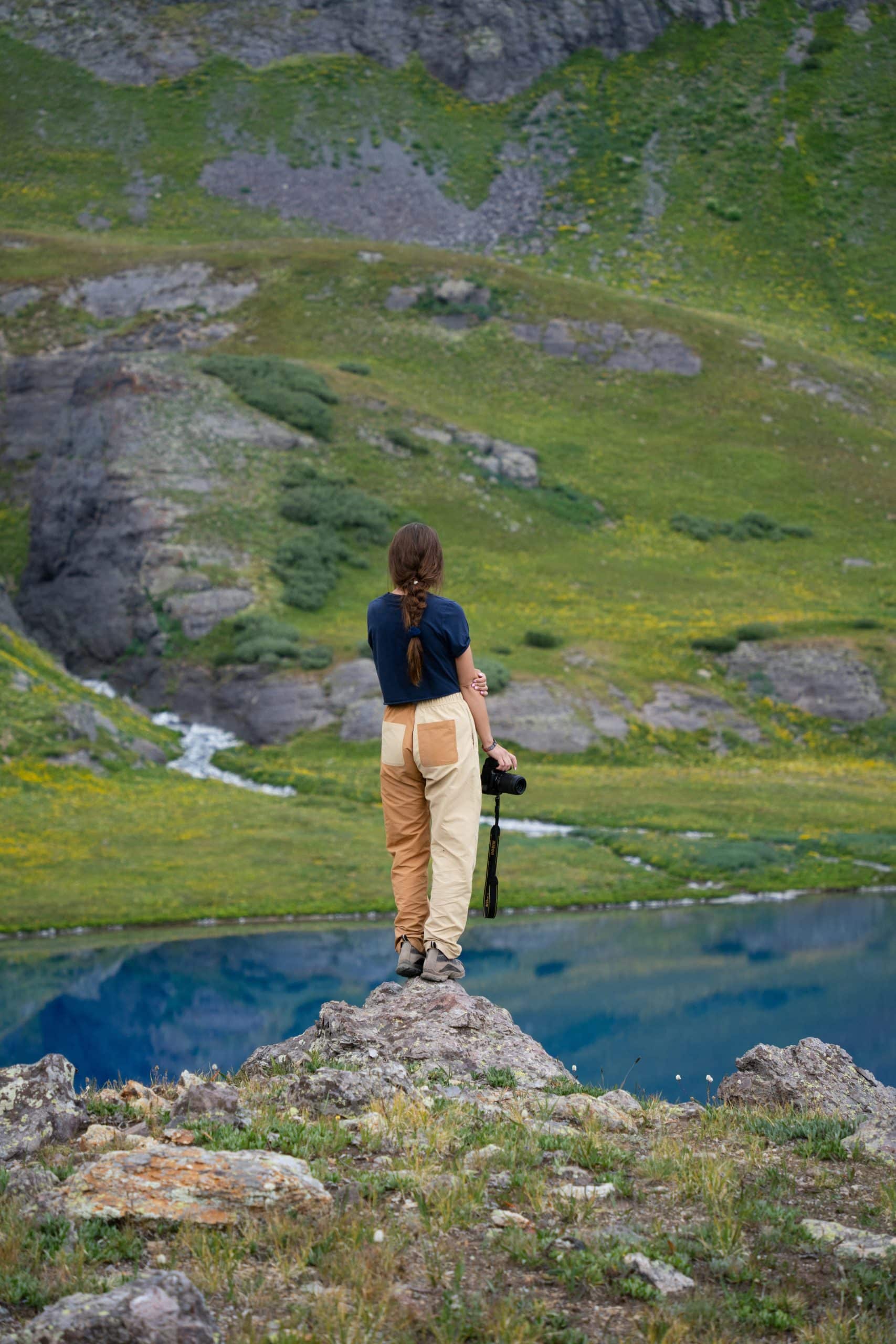 Solo female traveler standing confidently overlooking a scenic landscape Solo female traveler standing confidently overlooking a scenic landscape
