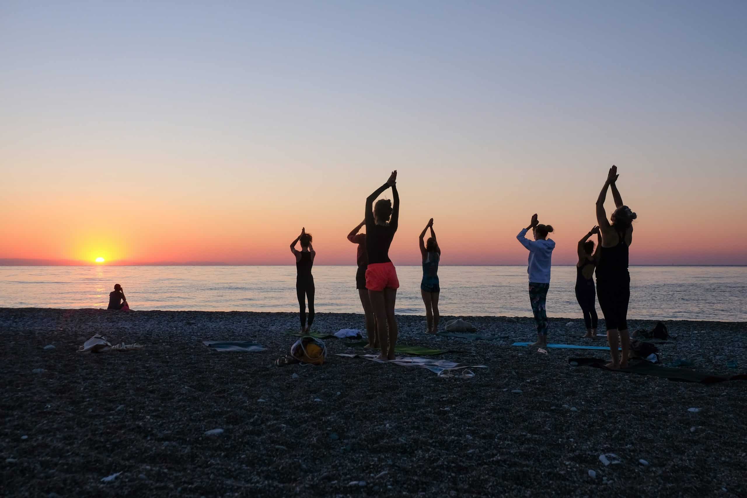 Yoga session on the beach in Tulum, Mexico, with women practicing as the sun sets over the Caribbean Sea. Yoga session on the beach in Tulum, Mexico, with women practicing as the sun sets over the Caribbean Sea.