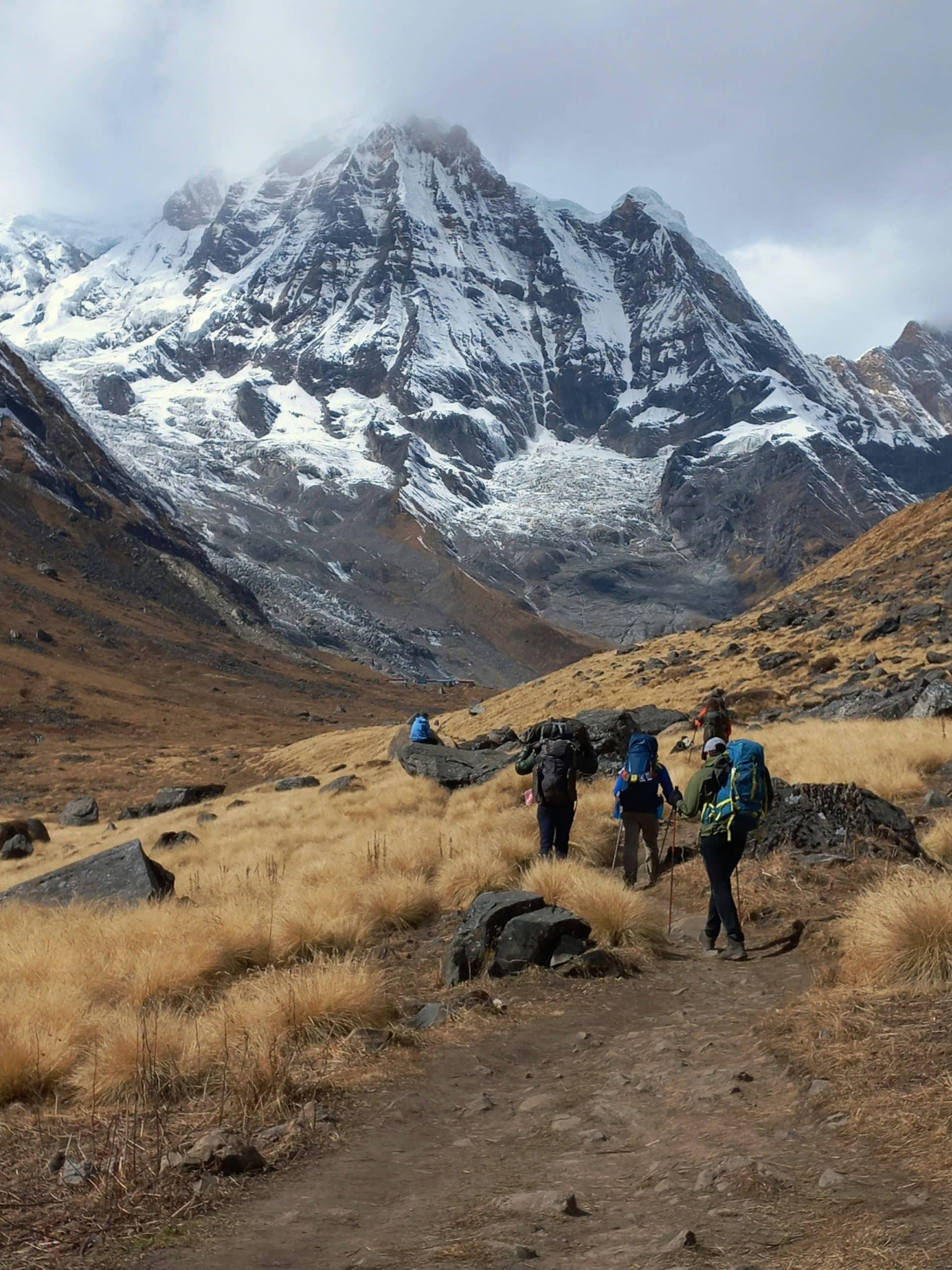 Trekker walking beneath the towering Salkantay Mountain in Peru, surrounded by glacier landscapes Trekker walking beneath the towering Salkantay Mountain in Peru, surrounded by glacier landscapes