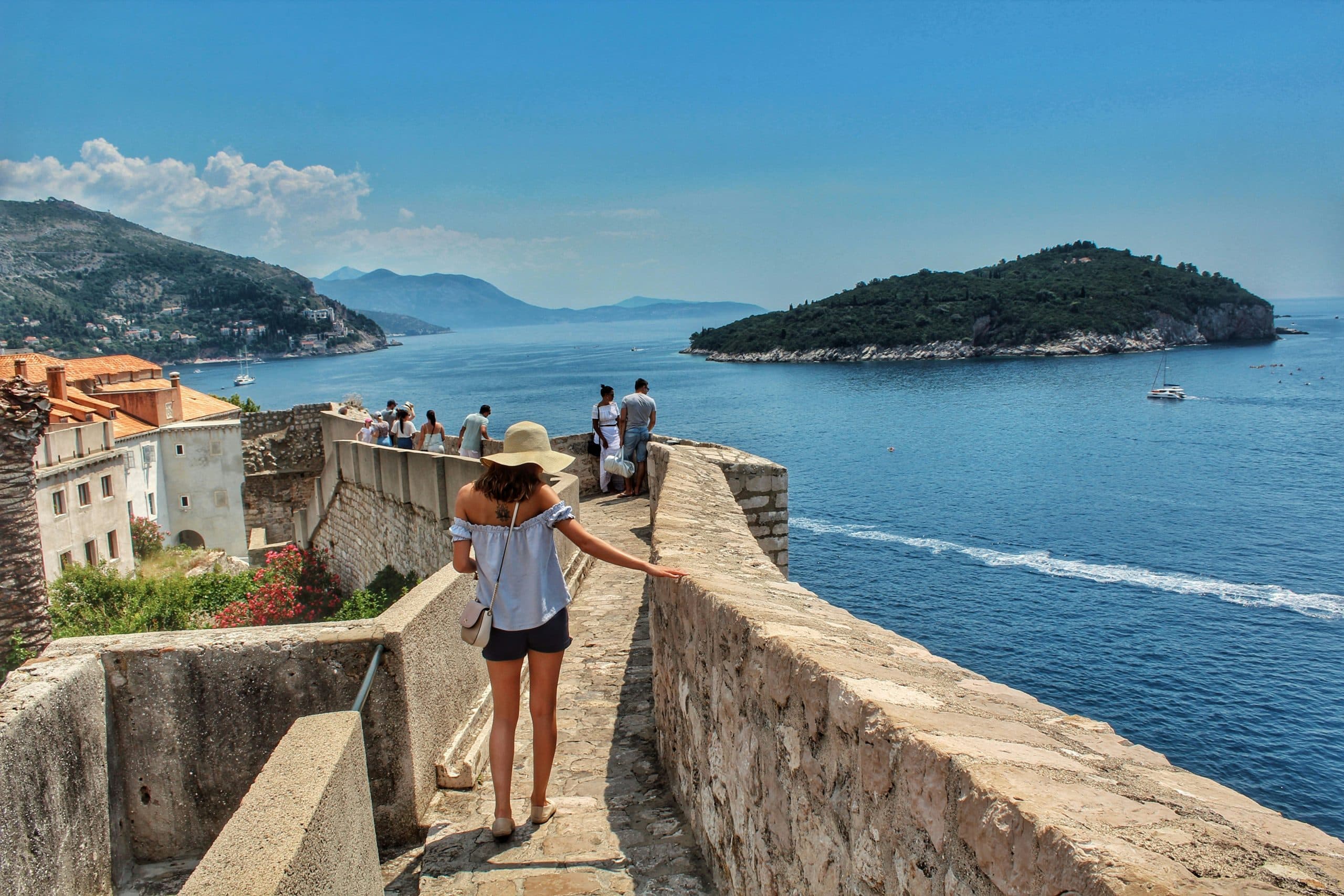 Female traveler exploring fortress walls overlooking Kotor Bay, Montenegro
