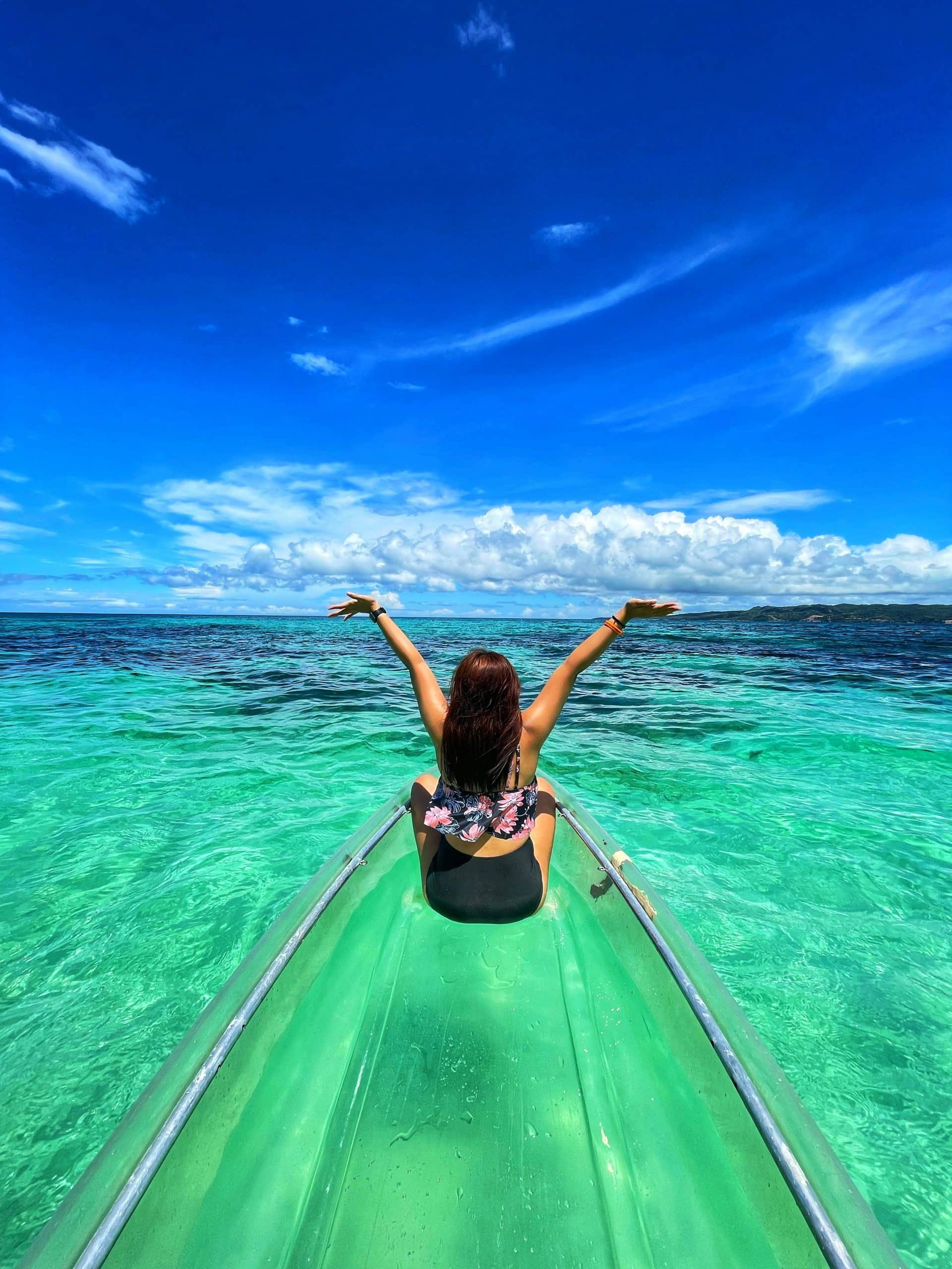 Solo female traveler on a long-tail boat surrounded by turquoise waters and limestone cliffs in southern Thailand. Solo female traveler on a long-tail boat surrounded by turquoise waters and limestone cliffs in southern Thailand.